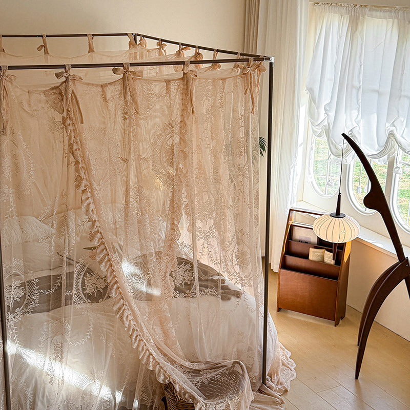Romantic lace canopy curtains on a four-poster bed in a cozy, sunlit bedroom