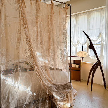 Romantic lace bed canopy curtains draped over four-poster bed in sunlit bedroom