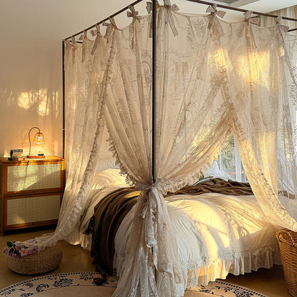 Romantic lace canopy curtains on a four-poster bed with cozy bedding in a sunlit bedroom.