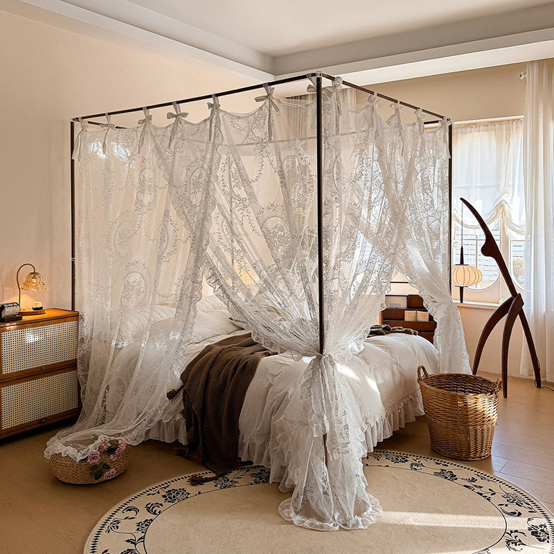 Romantic lace bed canopy curtains on a 4-poster bed in a cozy, elegant bedroom setting.