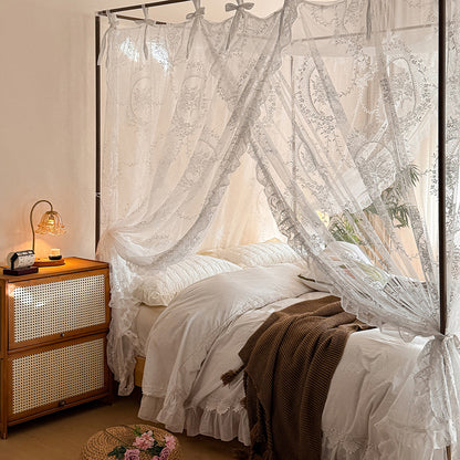 Romantic lace canopy curtains on a four-poster bed with soft white bedding in a cozy bedroom