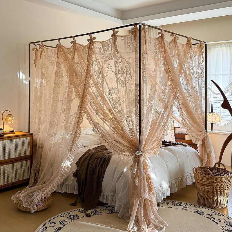 Romantic lace bed canopy curtains on a 4 poster bed in a cozy sunlit bedroom