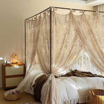 Bedroom with a canopy bed draped in lace curtains, wooden nightstand, and decorative elements.