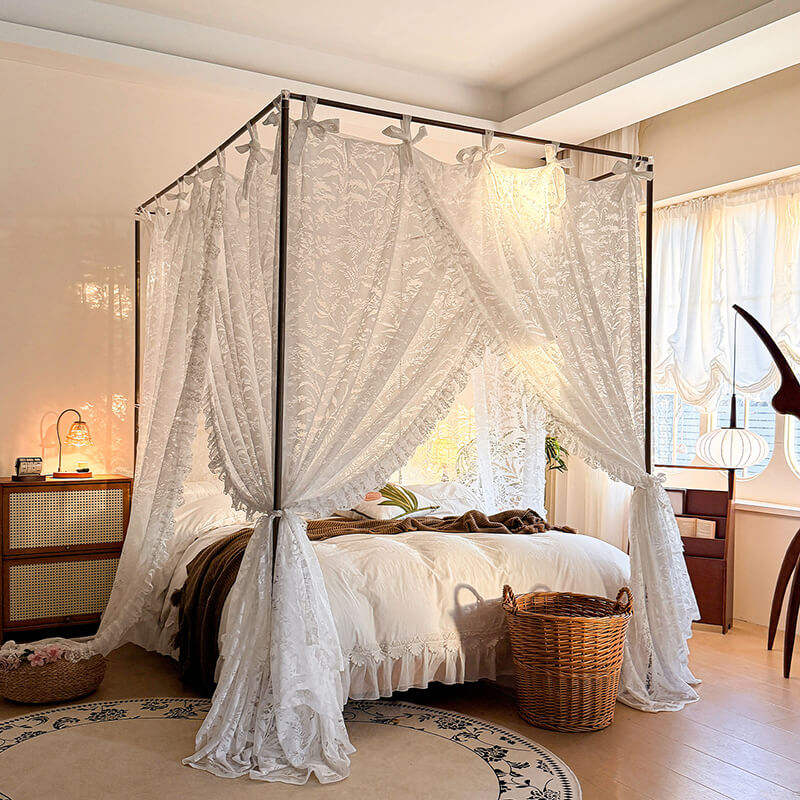 Four-poster bed with white lace curtains in a bedroom setting.