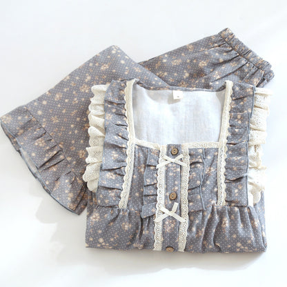 Blue floral cotton pajama set with lace ruffles and buttons, folded on white background