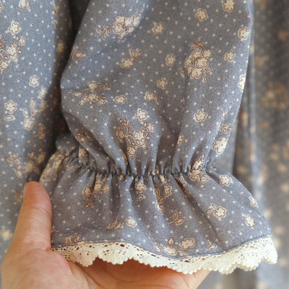 Close-up of blue floral cotton pajama sleeve with lace trim and ruffled cuff detail