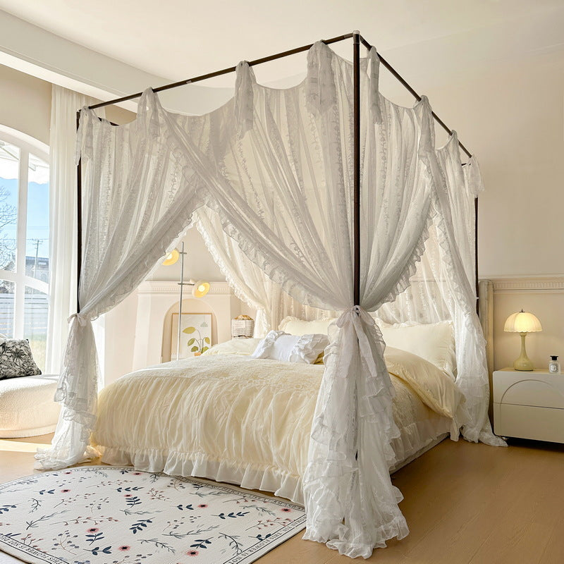 Romantic white lace canopy bed with ruffled curtains in a bright, cozy bedroom
