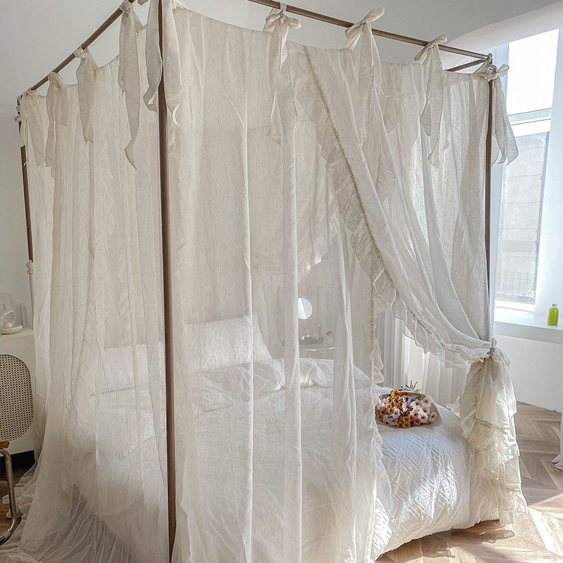 Romantic ruffled cotton canopy curtains on four-poster bed in bright, cozy bedroom