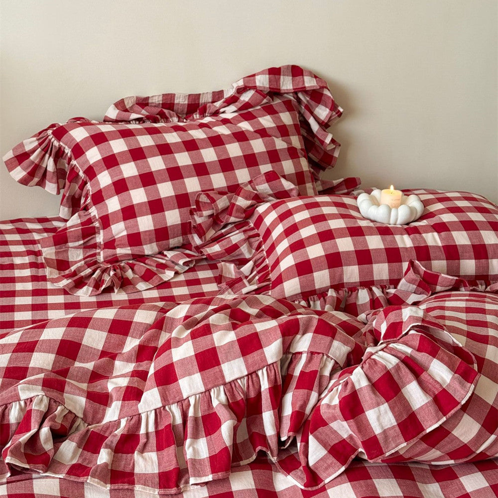 Red and white checkered bedding with ruffled edges on a bed.