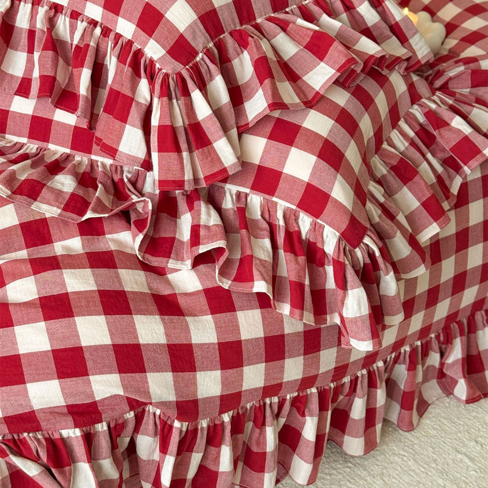 Detail of the tiered ruffles and red checkered pattern on the muslin duvet cover.