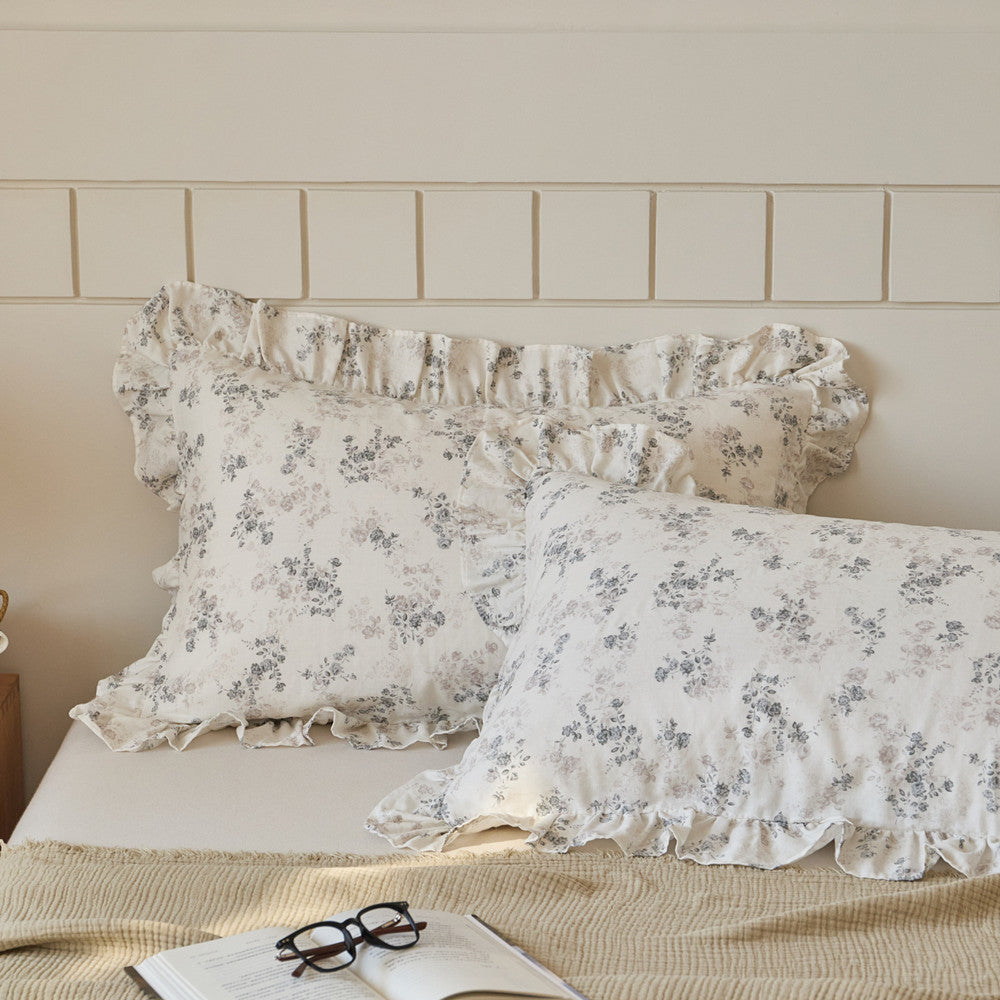 Pair of floral printed cotton muslin pillow shams with delicate ruffle trim, perfect for a layered bedding look