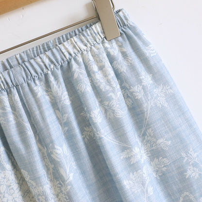 Soft blue cotton pajama pants with white floral print and elastic waistband on hanger