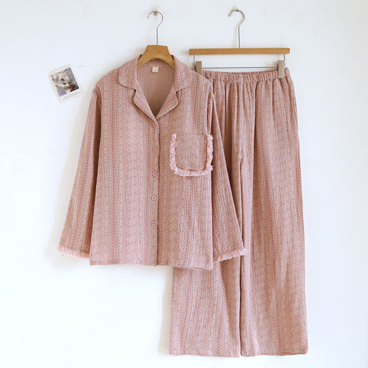 Soft pink cotton gauze pajama set with buttoned top and matching pants on hangers