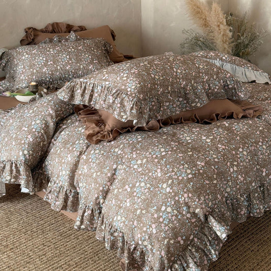 Close-up of the Earthy Floral Bedding Set in brown, highlighting the soft cotton muslin texture, delicate floral print, and ruffled edges.