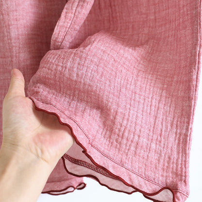 Hand holding soft pink cotton gauze pajama fabric with ruffled edge detail