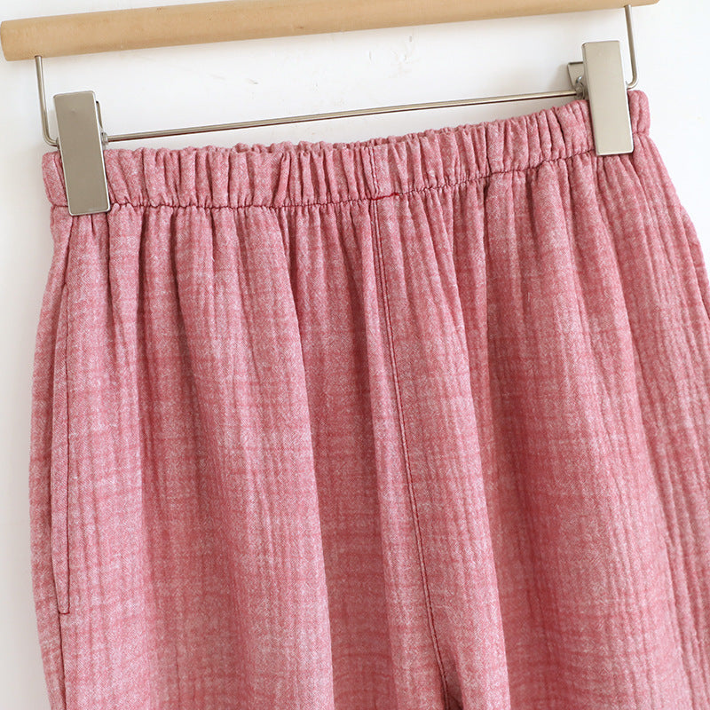 Soft pink cotton gauze women's pajama pants with elastic waistband, close-up view