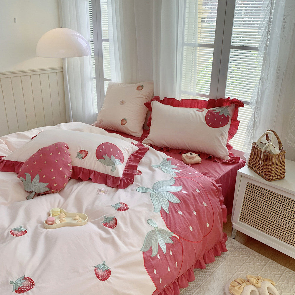 Pink strawberry cotton bedding set with ruffled edges in a cozy, sunlit bedroom