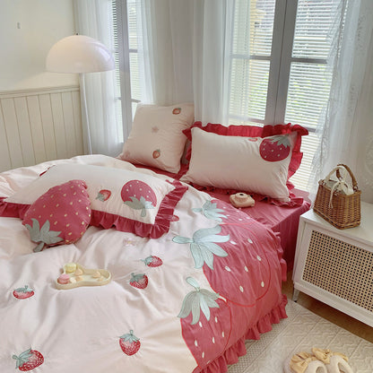 Pink strawberry cotton bedding set with ruffled edges in a cozy, sunlit bedroom