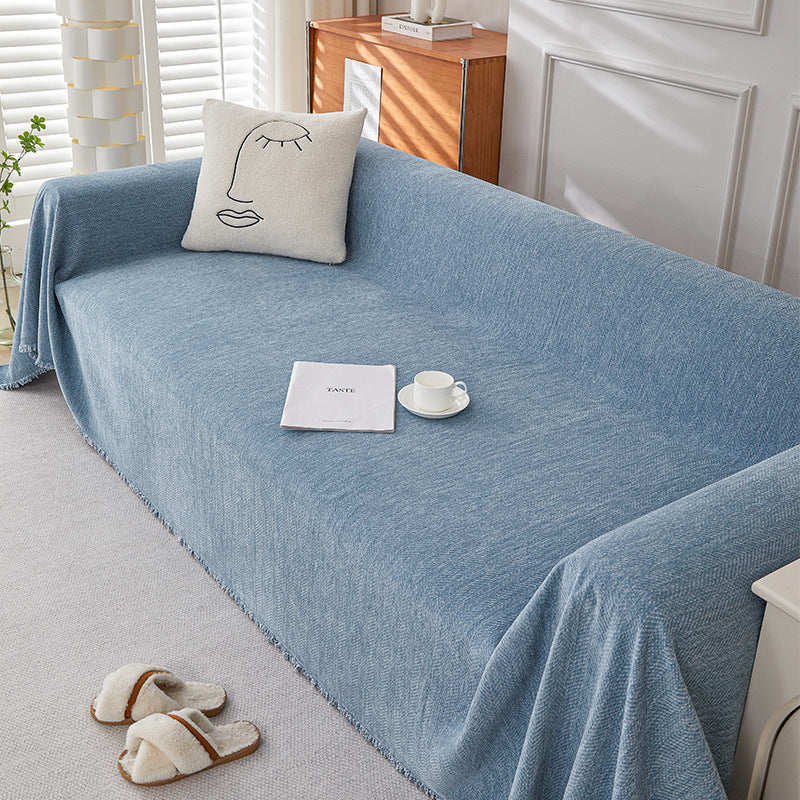 Textured blue herringbone chenille one-piece sofa cover in bright cozy living room