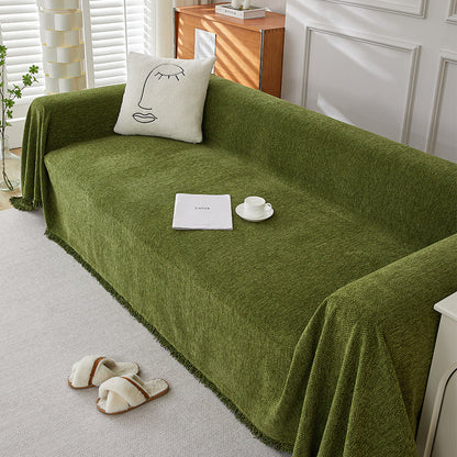 Textured green herringbone chenille sofa cover with minimalist pillow and cozy slippers