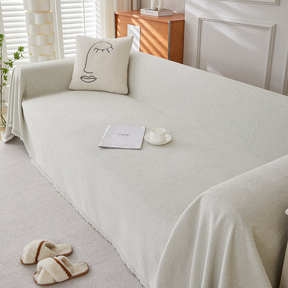 Textured herringbone chenille sofa cover in a bright living room, with minimalist pillow and slippers