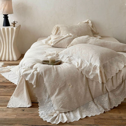 Beige textured linen cotton bedding set with embroidered lace trim on wooden floor