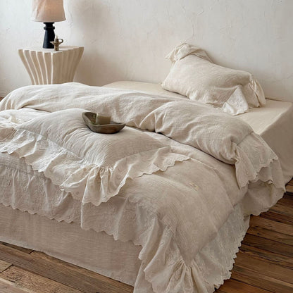 Textured linen cotton bedding set in beige with embroidered lace trim on bed in rustic room