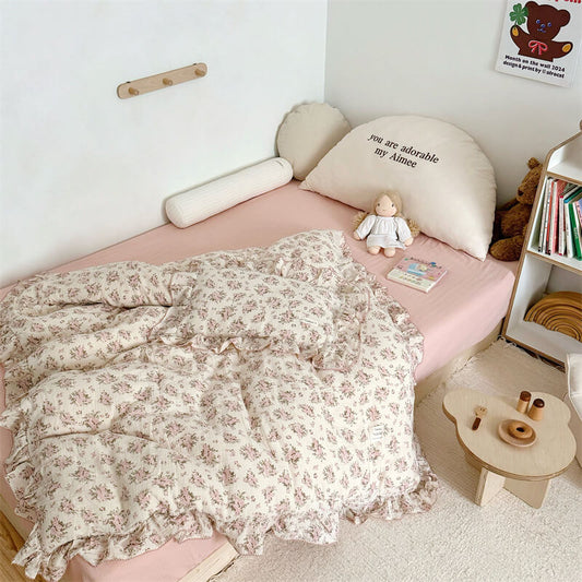 Twin-size floral bedding with ruffle duvet cover and shams on a bed in a cozy, bright room setting.