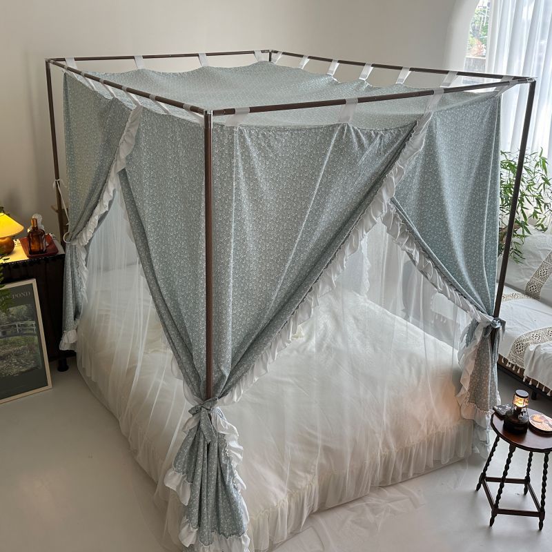 Vintage floral bed canopy with ruffled trim and sheer panels in cozy bedroom setting