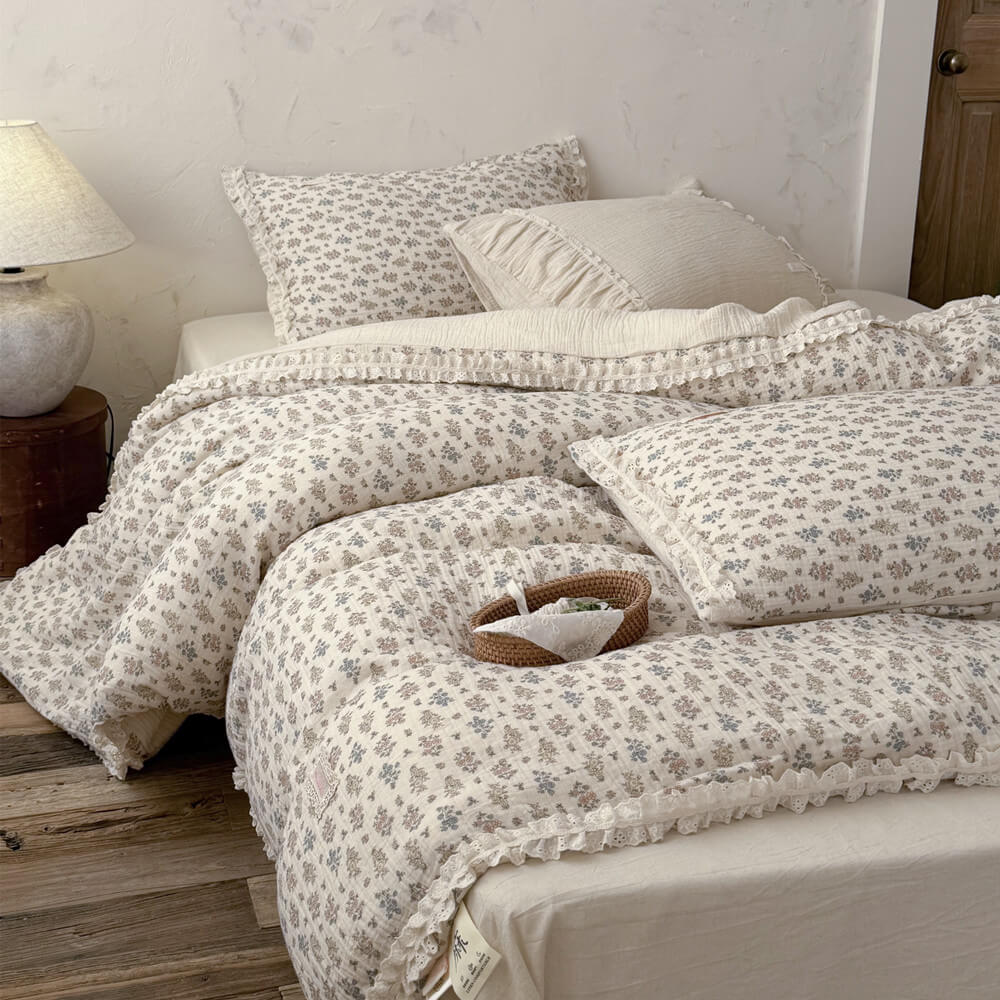A detailed close-up shot of two rustic pillows with small floral patterns and eyelet lace ruffle trim.