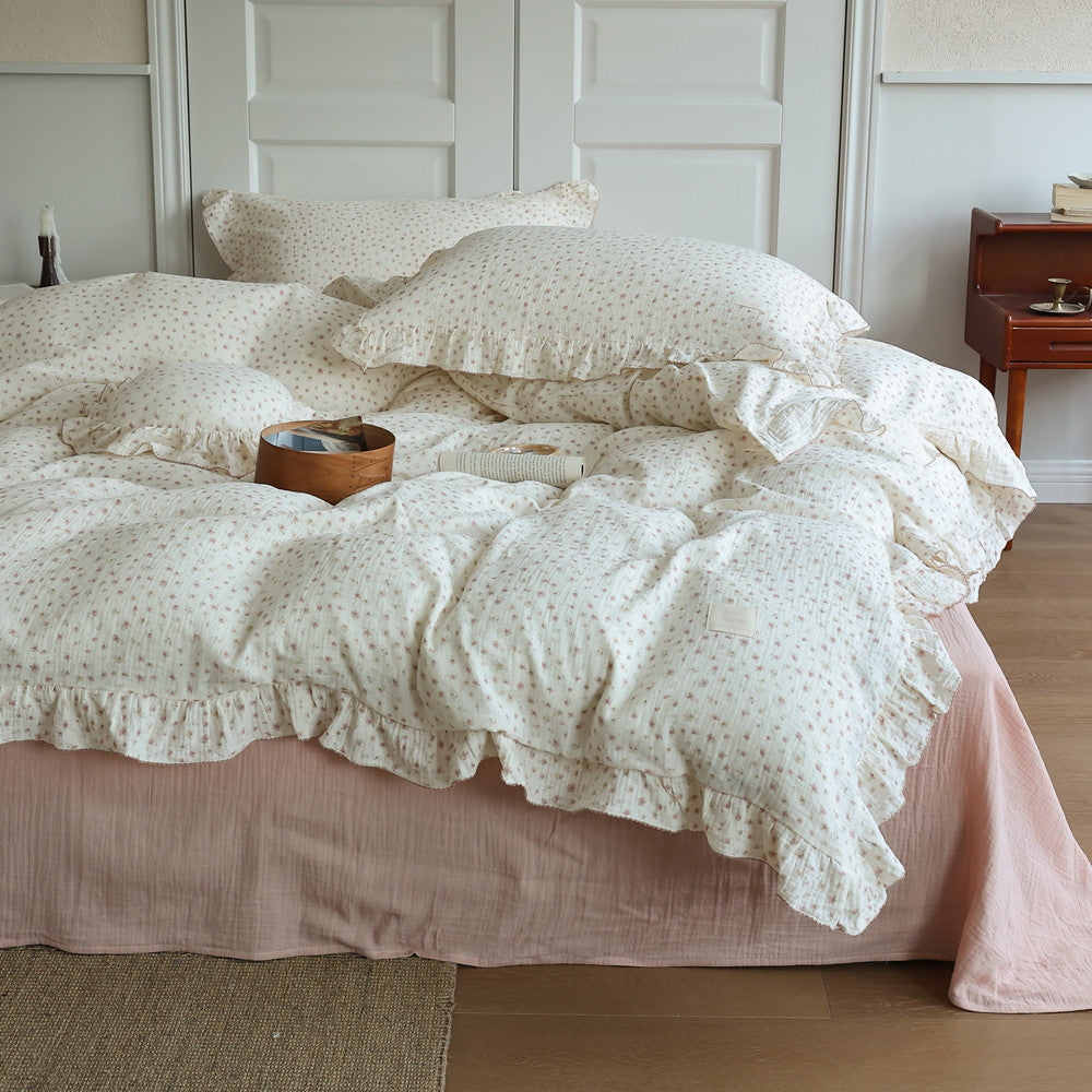 Ditsy Floral Cotton Gauze Duvet Cover Set on bed, featuring small floral print and ruffled edges.