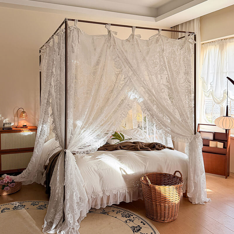 Bedroom with a canopy bed draped in lace curtains, wooden nightstands, and a rug.