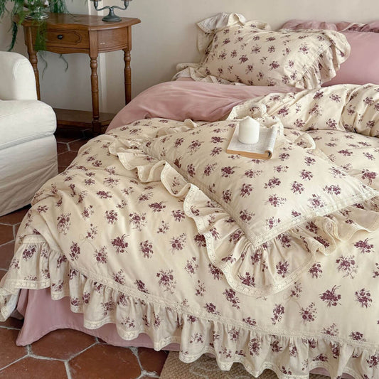 Close-up of vintage floral muslin duvet cover featuring ruffled lace edges and a romantic rose pattern.