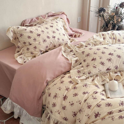 Elegant vintage rose muslin pillowcases with scalloped lace borders paired with solid pink bedding.