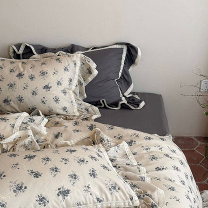 Shabby chic bedroom decor featuring grey vintage floral muslin pillowcases with white lace ruffles.