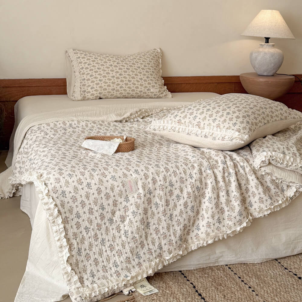 Front view of a country-style bed setup with a breathable cotton floral summer comforter and a small rattan basket.