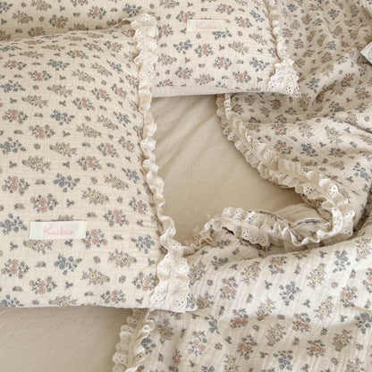 Top-down close-up shot of two cottagecore aesthetic pillows with tiny floral patterns and sweet eyelet lace ruffle trim.
