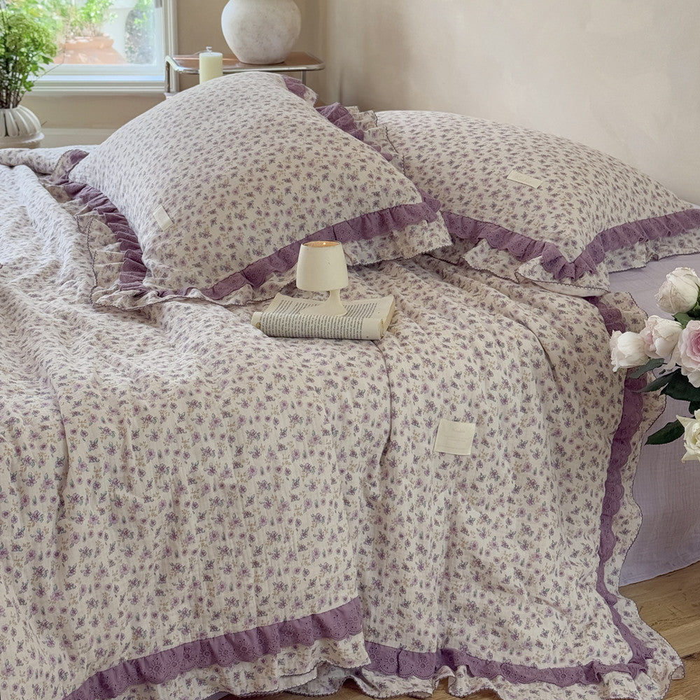 Lightweight floral comforter draped over wooden floor and soft sheet