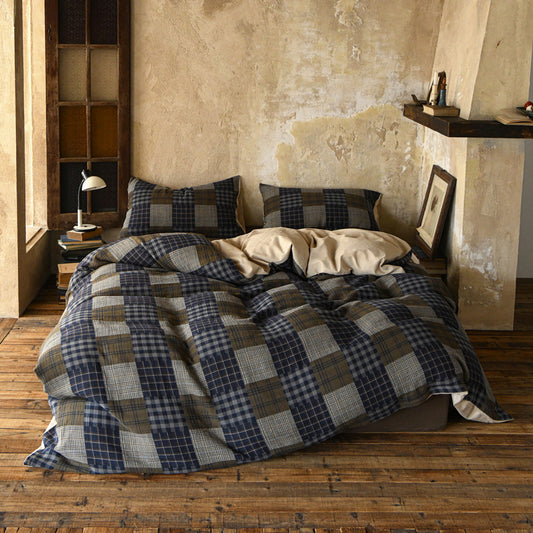 Bed with plaid bedding in a rustic bedroom setting