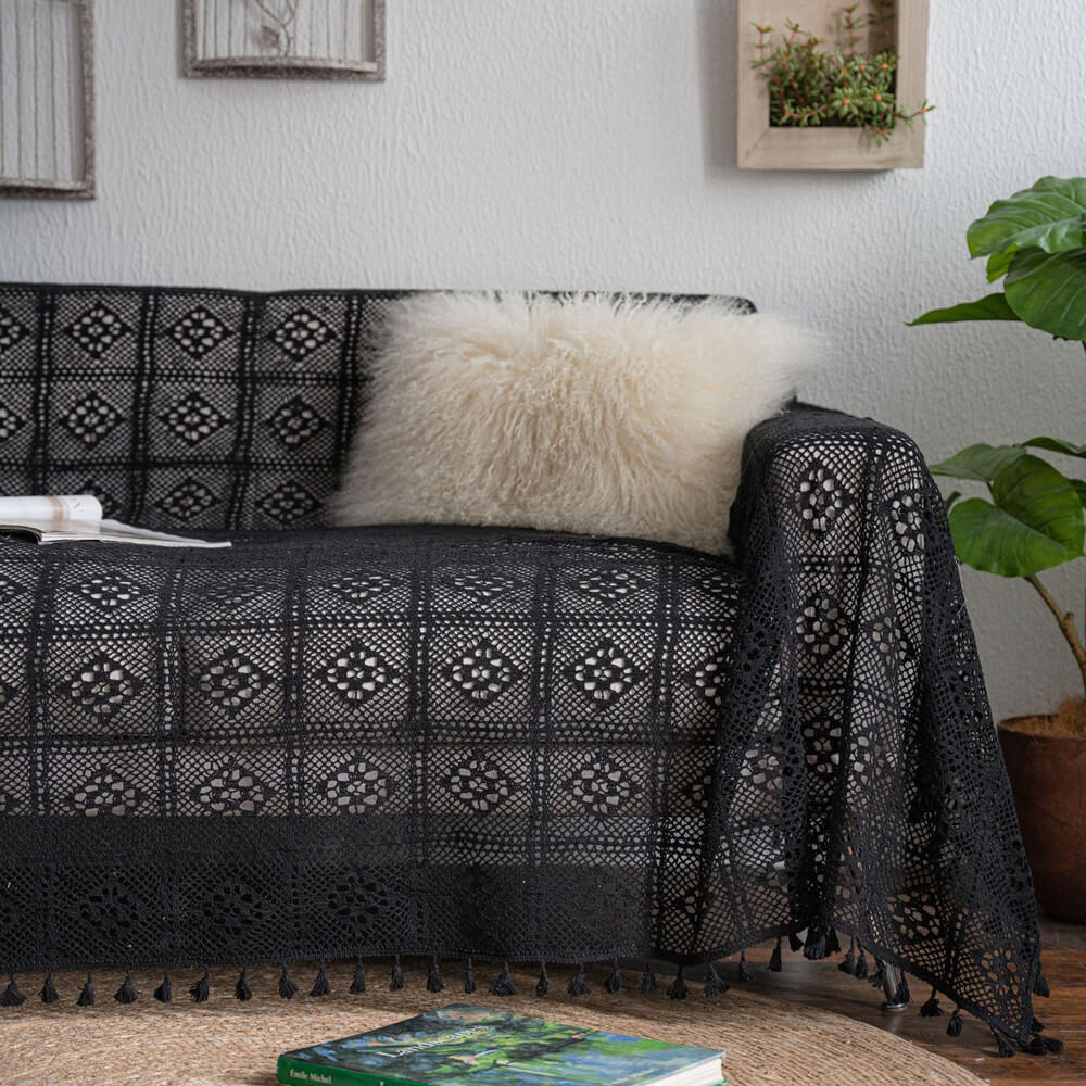 Vintage black crochet lace sofa cover with tassel trim, fluffy pillow, and cozy home decor