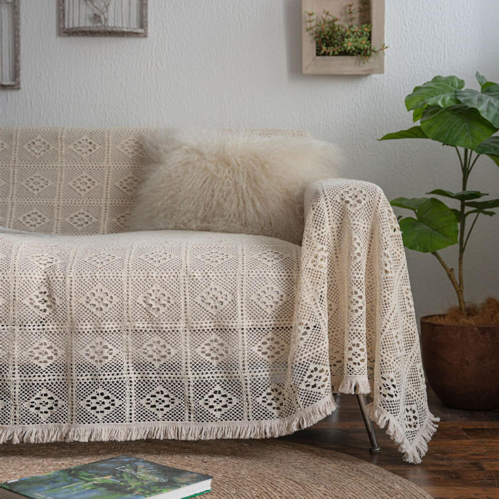 Cream crochet lace sofa cover with tassel trim in a cozy living room, StuffedHome decor