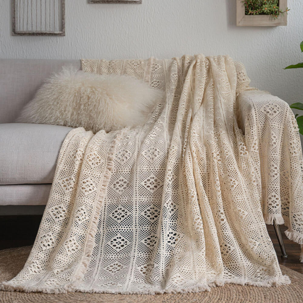 Vintage crochet lace sofa cover with tassel trim draped on a beige couch, StuffedHome decor