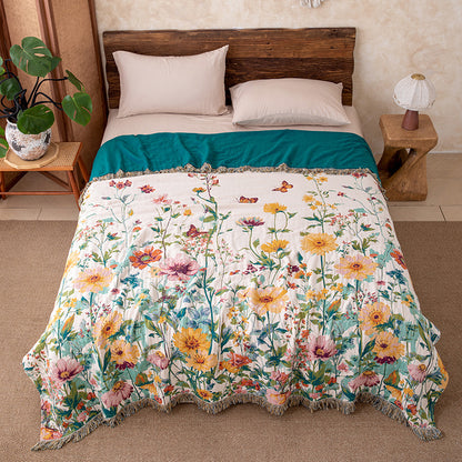 Wildflower garden cotton throw blanket with fringe styled on a bed