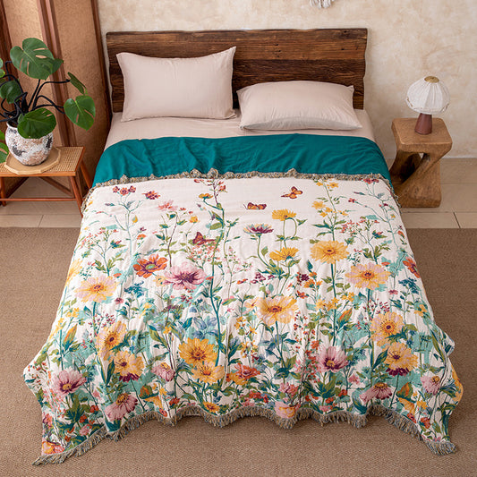 Wildflower garden cotton throw blanket with fringe styled on a bed