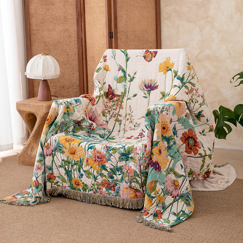 Wildflower garden cotton throw blanket draped over an accent chair