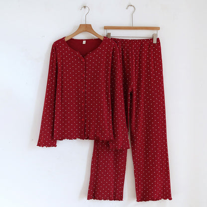 Red cotton pajama set for women with long sleeves and white heart print, hung on hangers