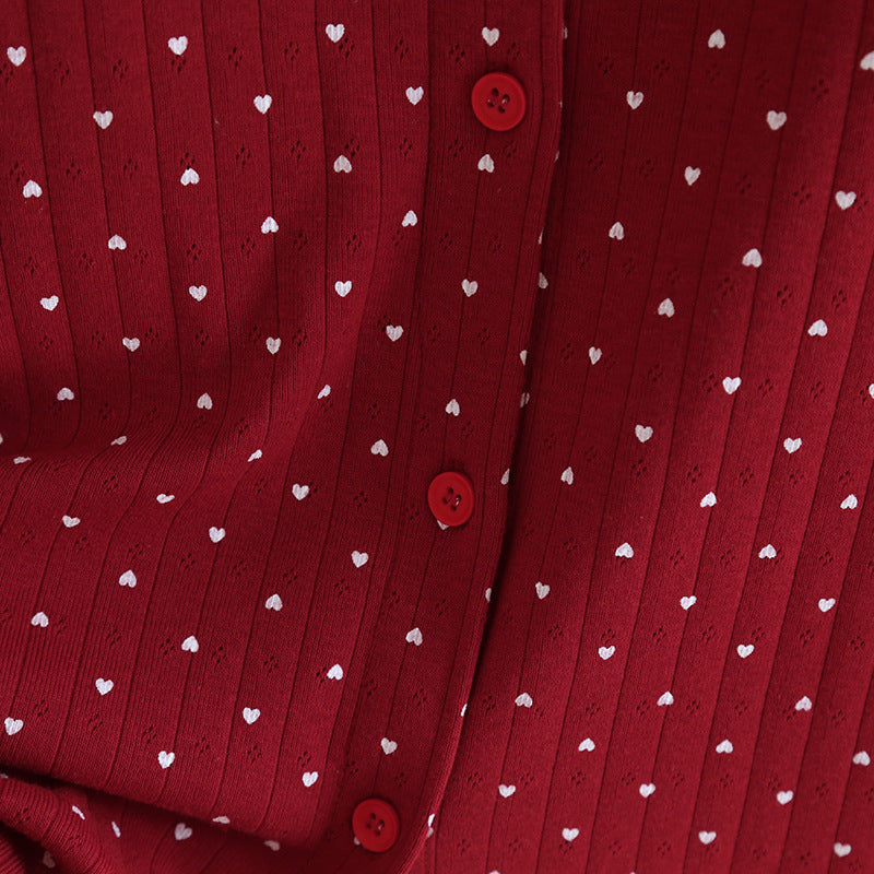 Close-up of red cotton pajama top with white heart print and red buttons