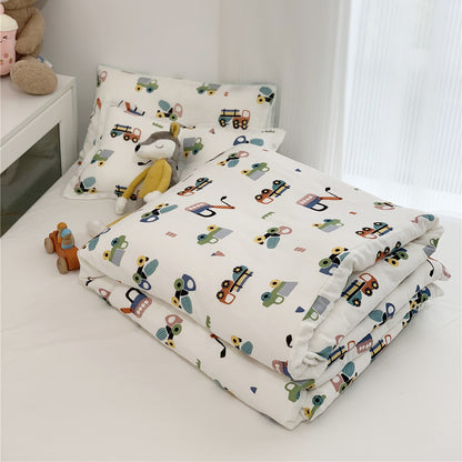 Folded Twin Size Bamboo Duvet Cover and pillow set with a bright construction vehicle print on a white bed.