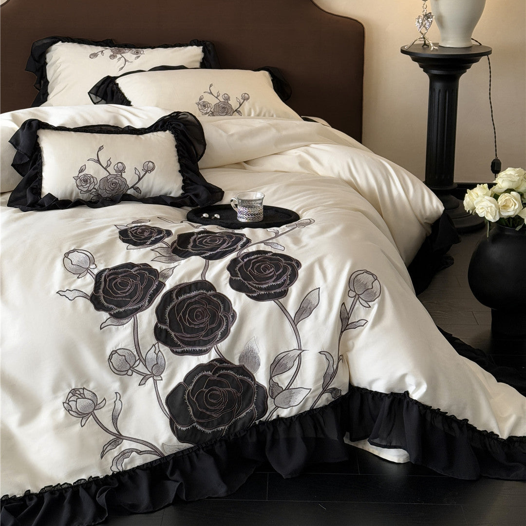 Angled view of duvet and pillows with black lace edges