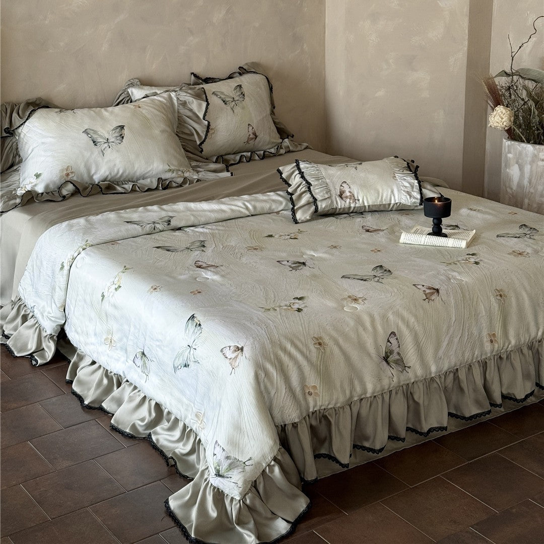 Close-up of butterfly print comforter corner with lace and ruffle detail